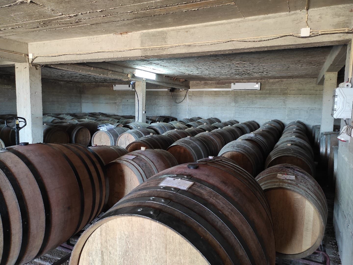 Vista alargada de uma adega de vinhos com sistemas de ar condicionado instalados