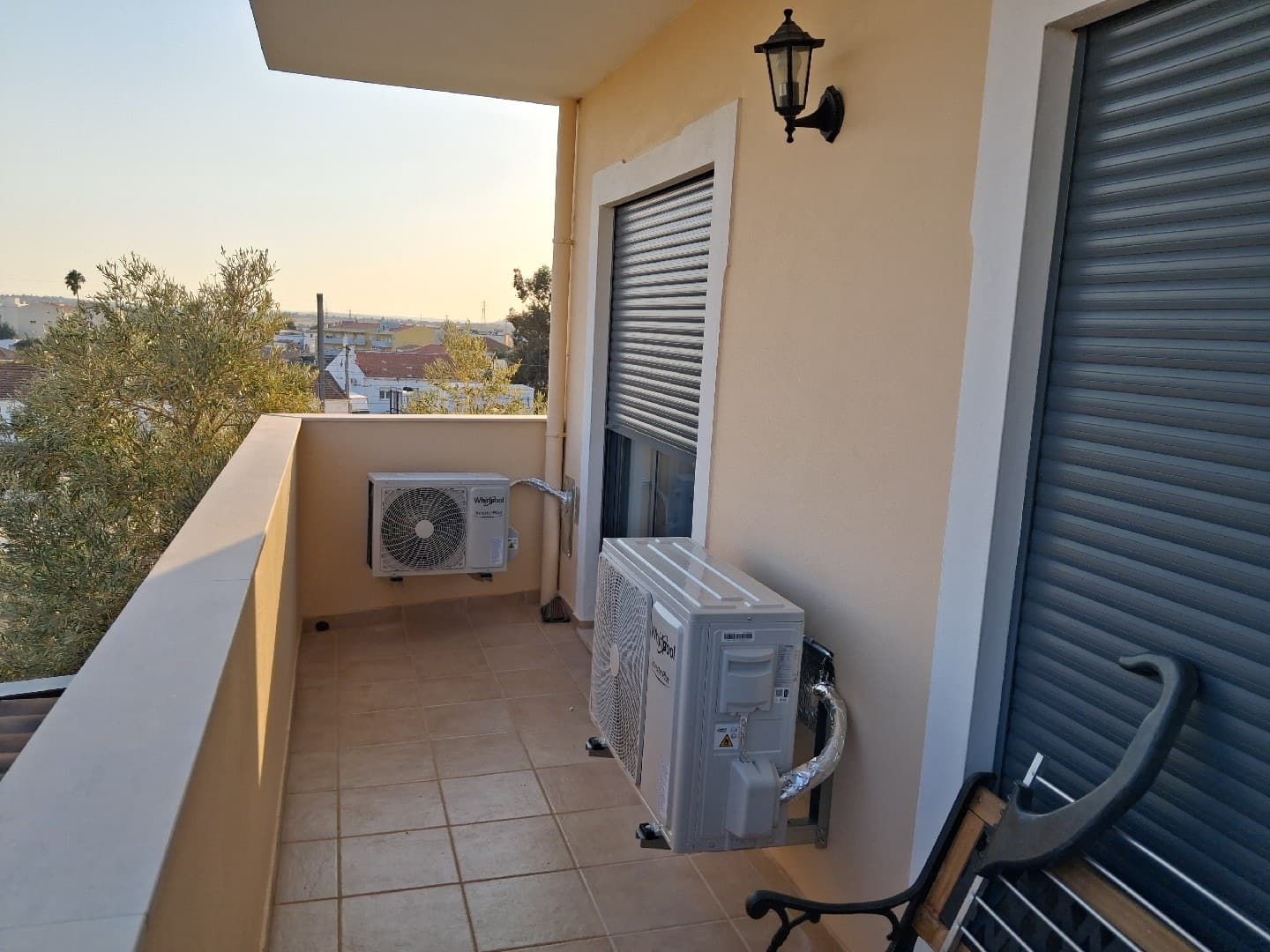 Unidades exteriores de ar condicionado instaladas numa varanda ao pôr do sol
